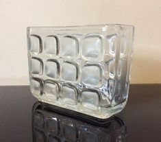 a glass vase sitting on top of a table