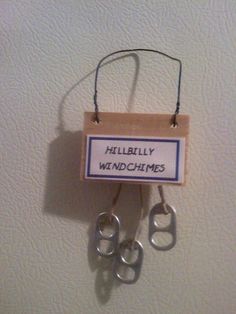 a sign hanging on the wall that says hillbilly wind chimes with two pairs of scissors attached to it