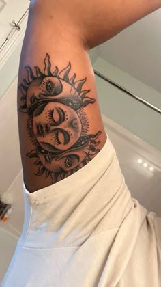 a person with a sun and moon tattoo on their arm