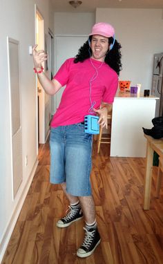 a woman in pink shirt and headphones standing on wooden floor