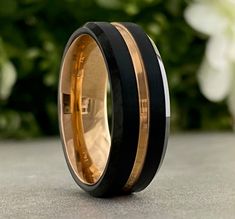 two tone gold and black ceramic ring with rose bush in the backgrounge