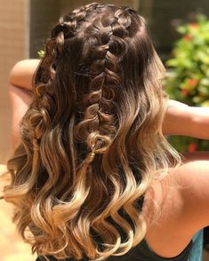 the back of a woman's head with long, curly hair in braids