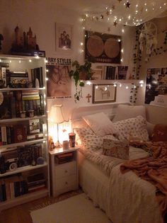 a bedroom with lights strung from the ceiling and bookshelves on the wall above the bed