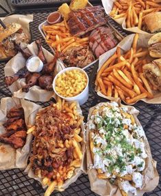 a table topped with lots of different types of food next to french fries and coleslaw