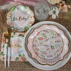 a table set with plates, silverware and napkins for a baby shower party