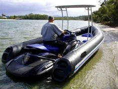 a man riding on the back of a blue and black boat