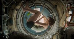 a woman hanging upside down in a space station