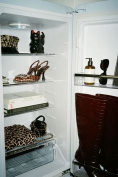 an open refrigerator filled with lots of shoes and handbags