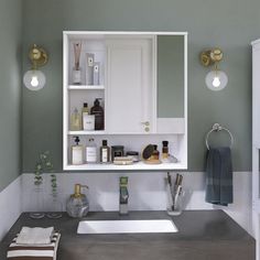 a bathroom sink with an open medicine cabinet above it and other items on the counter