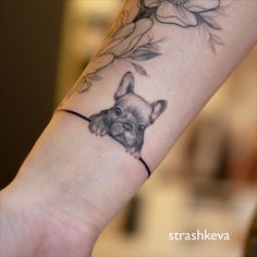 a tattoo on the arm of a person with a dog's head and flowers