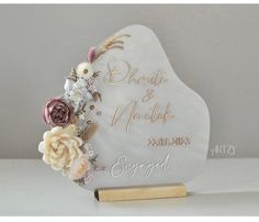 a white heart shaped plaque with flowers on it