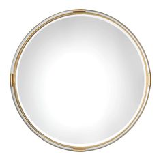 a round mirror with gold trimmings and a white back dropper on the bottom