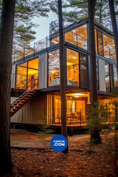 a house made out of shipping containers in the woods at night with stairs leading up to it