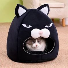 a cat is hiding in a black kitty bed