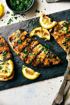 grilled fish with lemons and herbs on a cutting board