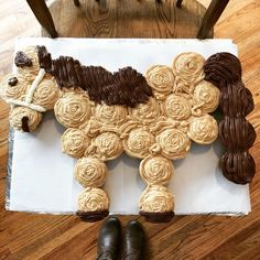 a cake made to look like a horse is sitting on the floor next to a pair of shoes