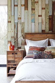 a bed that has some pillows on it and a lamp in front of the headboard