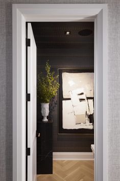 an open door leading to a room with black and white walls