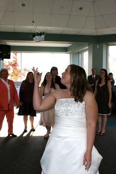 a woman in a white dress standing next to other people