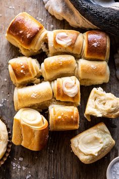 several rolls with butter on them sitting next to a glass of milk and some other food items