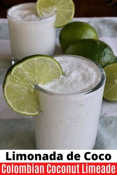 two glasses filled with white liquid and limes