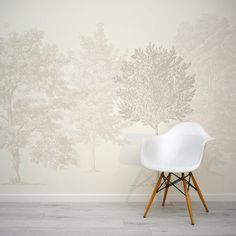 a white chair sitting in front of a wall with trees on it