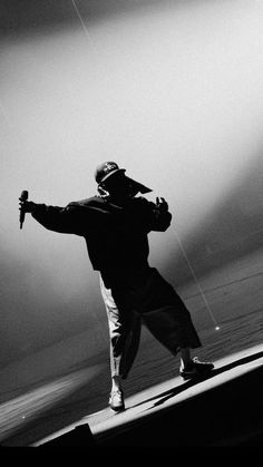 a man standing on top of a stage while holding a kite in the air above his head