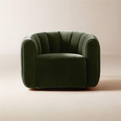 a green chair sitting on top of a floor next to a white wall with a pink background