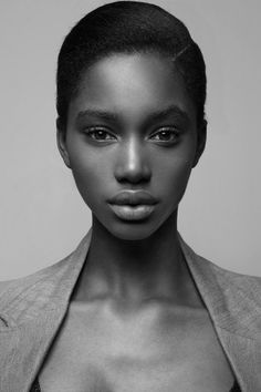 a woman in a suit and bra posing for the camera with her shirt open,