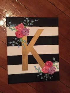 the letter k is decorated with flowers on black and white striped paper, along with pink roses