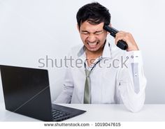 a man holding his head in front of a laptop computer and screaming at the screen