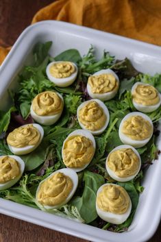 an egg salad in a white dish on a wooden table