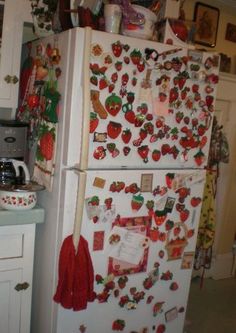 a refrigerator covered in magnets and christmas decorations