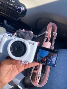 a person is holding up a camera in their hand while they are sitting in the car