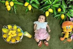 a baby laying on the ground next to some lemons