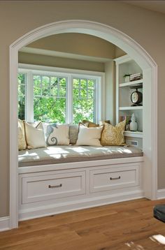 a window seat in the corner of a room with built - in bookshelves