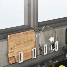 a cutting board and knife holder on a kitchen counter next to a sink with lemons