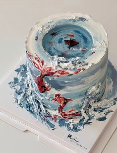 a cake with red and blue frosting on it sitting on top of a white box