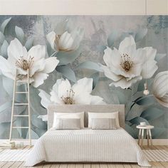 a bed sitting under a large white flower wall mural