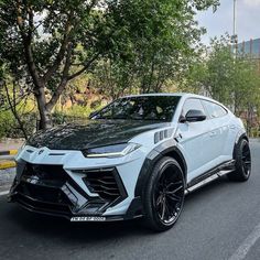 a white lamb suv is parked on the street