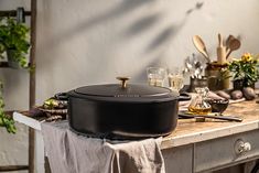 a pot on top of a table with utensils