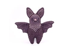 a stuffed animal bat sitting on top of a white surface