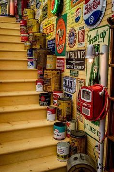 there are many signs on the wall next to the stairs that lead up to the second floor