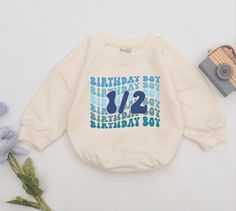 a birthday sweatshirt with the number two on it next to flowers and a toy car