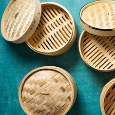 four bamboo baskets sitting on top of a blue surface