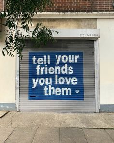 a closed garage door with the words tell your friends you love them