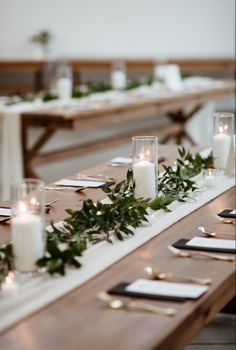 the table is set with candles and greenery