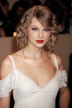 a close up of a person wearing a white dress and red lipstick on her lips