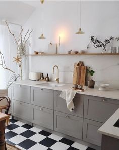 a kitchen with black and white checkered flooring next to a dining room table