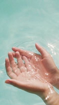 a person holding their hand out in the water